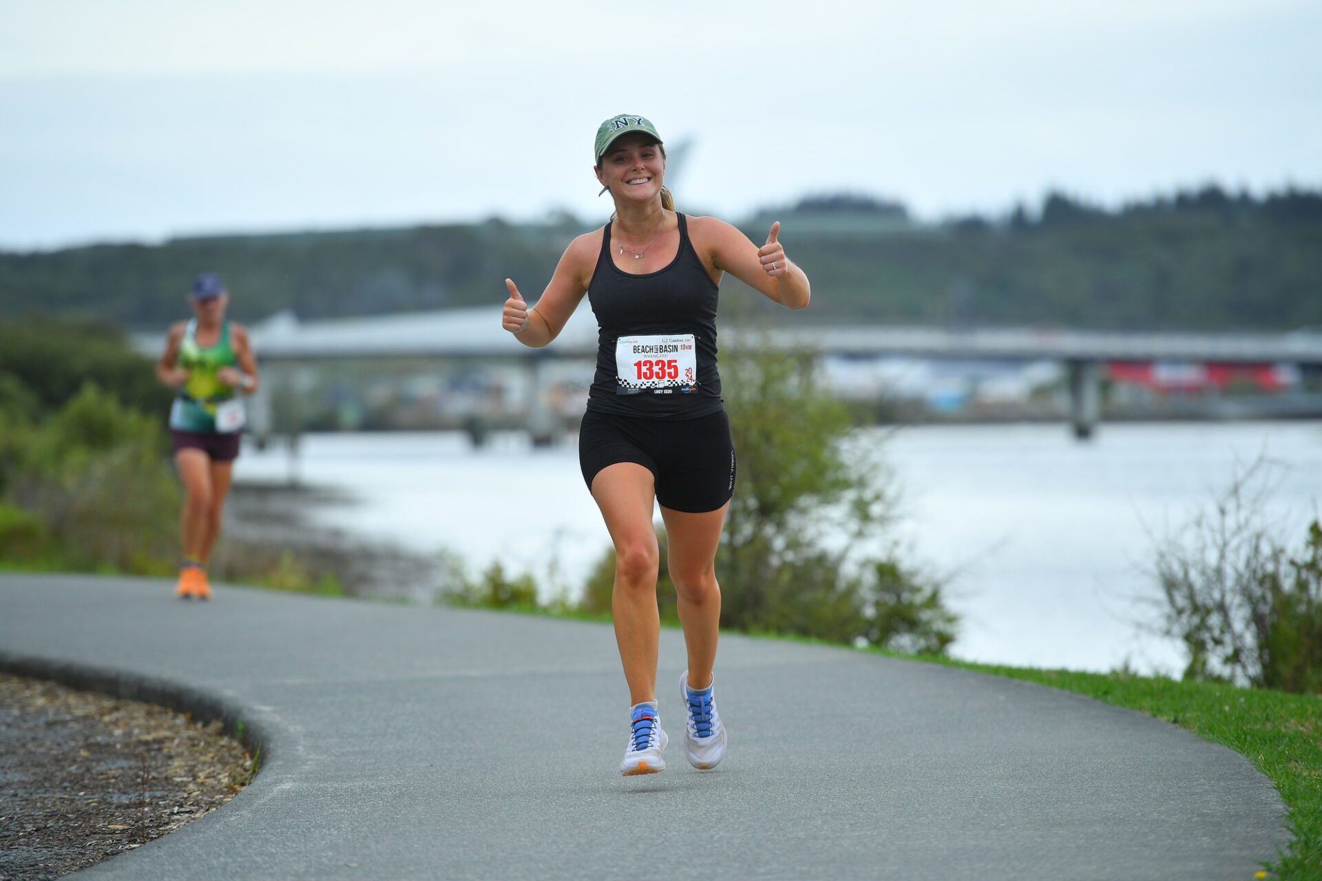 Woman gives thumbs up while running
