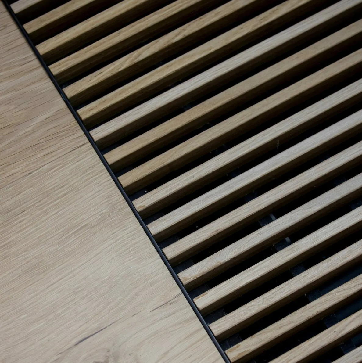 HVAC design: Close-up of a wooden slatted floor vent with a black metal frame